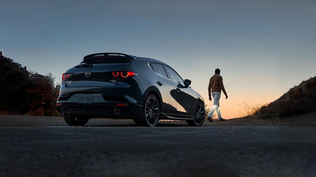 black 2024 mazda 3 facing a sunset